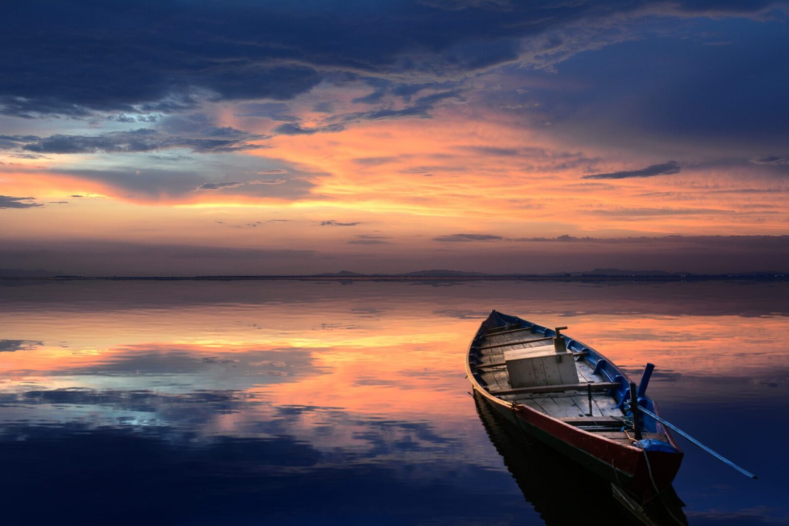 A boat is sitting in the water at sunset.