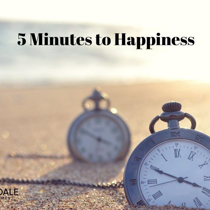 Two clocks sitting on top of a beach.